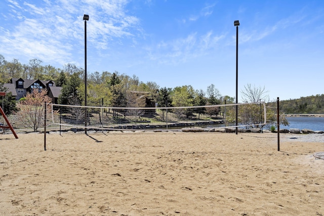 view of property's community with a water view and volleyball court