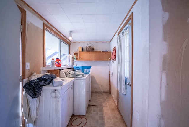 laundry room with washing machine and dryer and cabinets