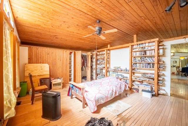 bedroom featuring wood-type flooring, wood ceiling, wood walls, and ceiling fan