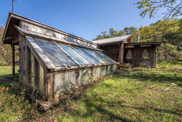 exterior space featuring a lawn and an outbuilding