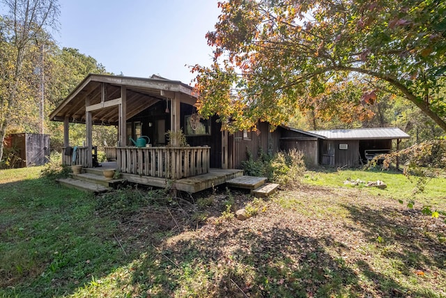 back of house with a lawn and a deck