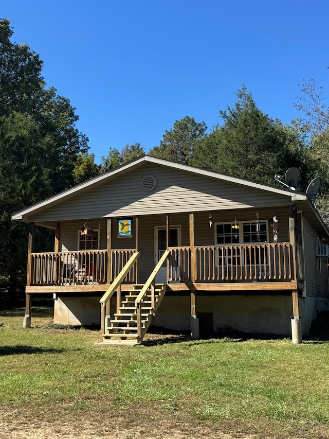 back of property with a wooden deck and a lawn