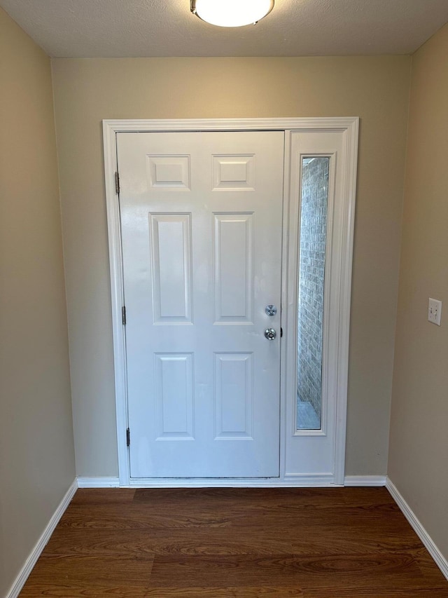 foyer entrance featuring dark hardwood / wood-style floors and a textured ceiling