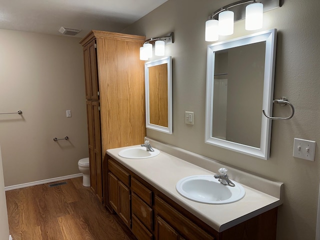 bathroom featuring wood-type flooring, vanity, and toilet