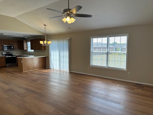 unfurnished living room with ceiling fan with notable chandelier, vaulted ceiling, dark hardwood / wood-style flooring, and sink