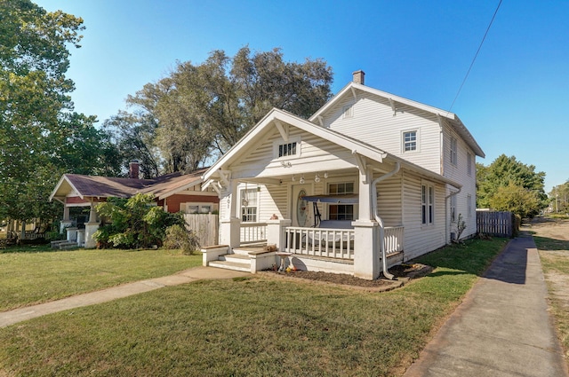 view of front facade with a front yard and covered porch