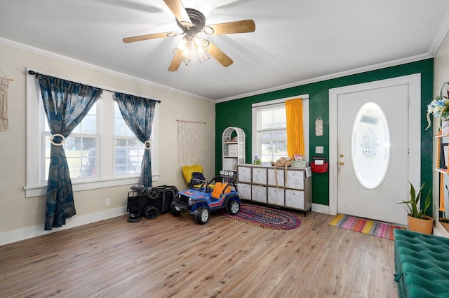 entrance foyer featuring light hardwood / wood-style floors, ornamental molding, and ceiling fan