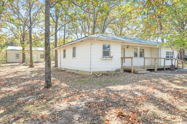 view of front of home with a shed and a deck