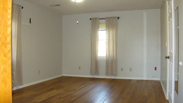 unfurnished room featuring dark wood-type flooring and ceiling fan