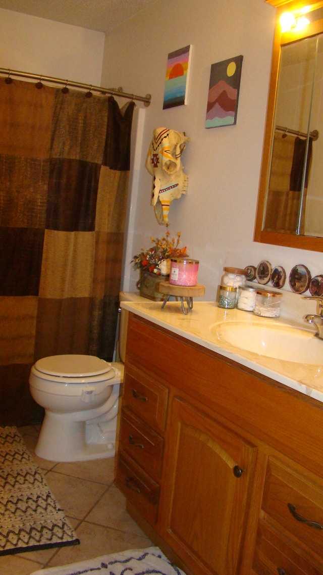 bathroom with tile patterned flooring, vanity, and toilet