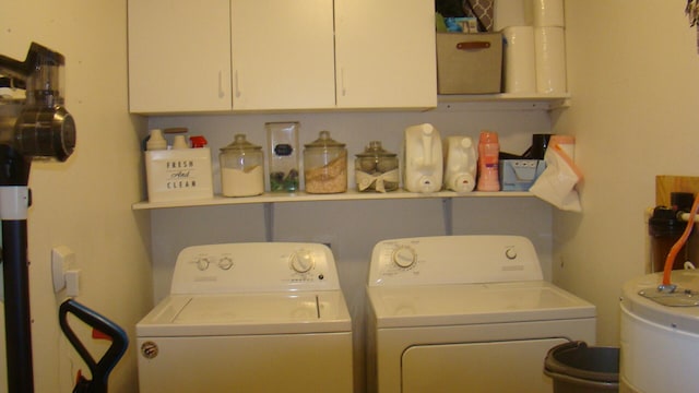 washroom with water heater, separate washer and dryer, and cabinets