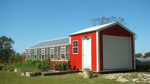 view of outdoor structure with a garage and a lawn