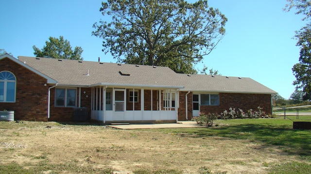 rear view of house with a sunroom and a lawn