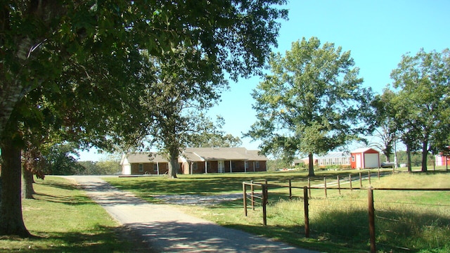 view of community with a rural view and a lawn