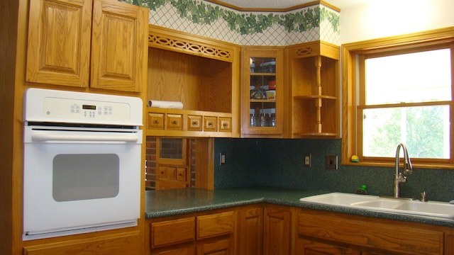 kitchen with sink, oven, and tasteful backsplash