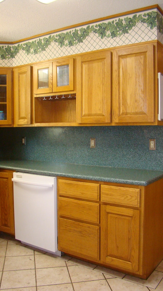 kitchen with decorative backsplash, light tile patterned floors, and dishwasher