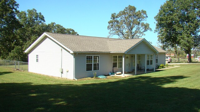 back of property featuring a yard