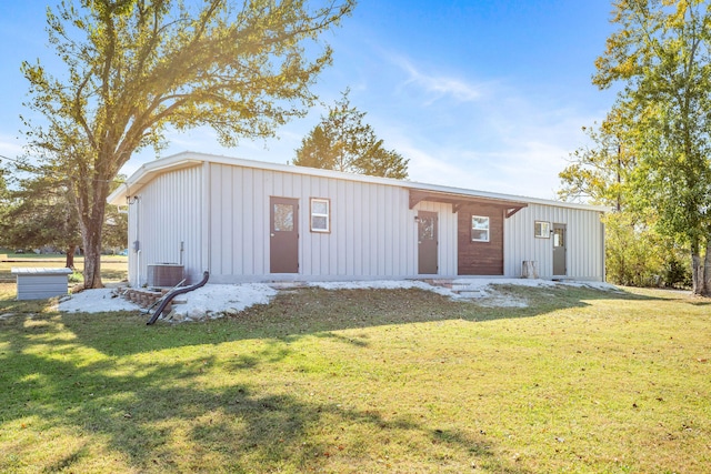 view of outbuilding with central AC unit and a lawn