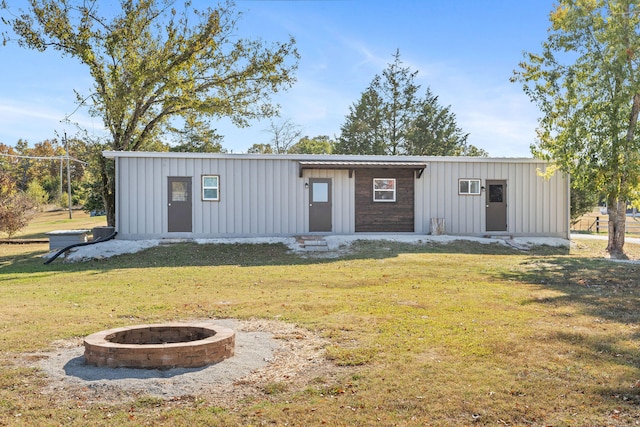 view of outdoor structure with a yard and an outdoor fire pit