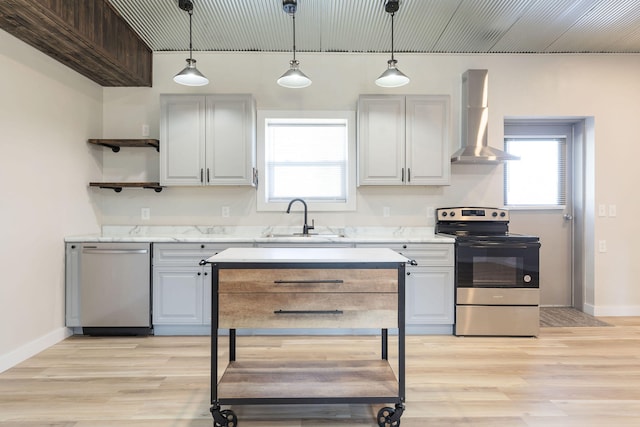 kitchen with wall chimney exhaust hood, plenty of natural light, stainless steel appliances, and light wood-type flooring