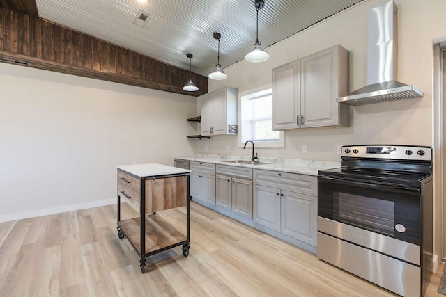 kitchen featuring wall chimney exhaust hood, gray cabinetry, electric range, decorative light fixtures, and sink