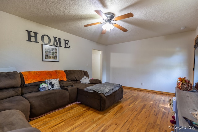 living room with wood-type flooring, a textured ceiling, and ceiling fan