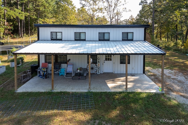 rear view of house featuring a lawn and a patio area