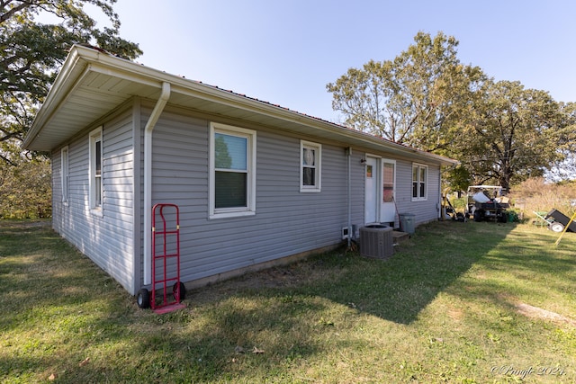 view of side of property with a lawn and central air condition unit