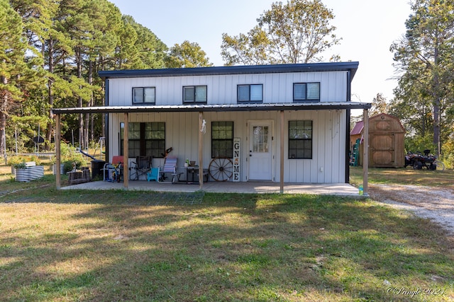 view of front of home featuring a patio area, a front yard, and a storage unit