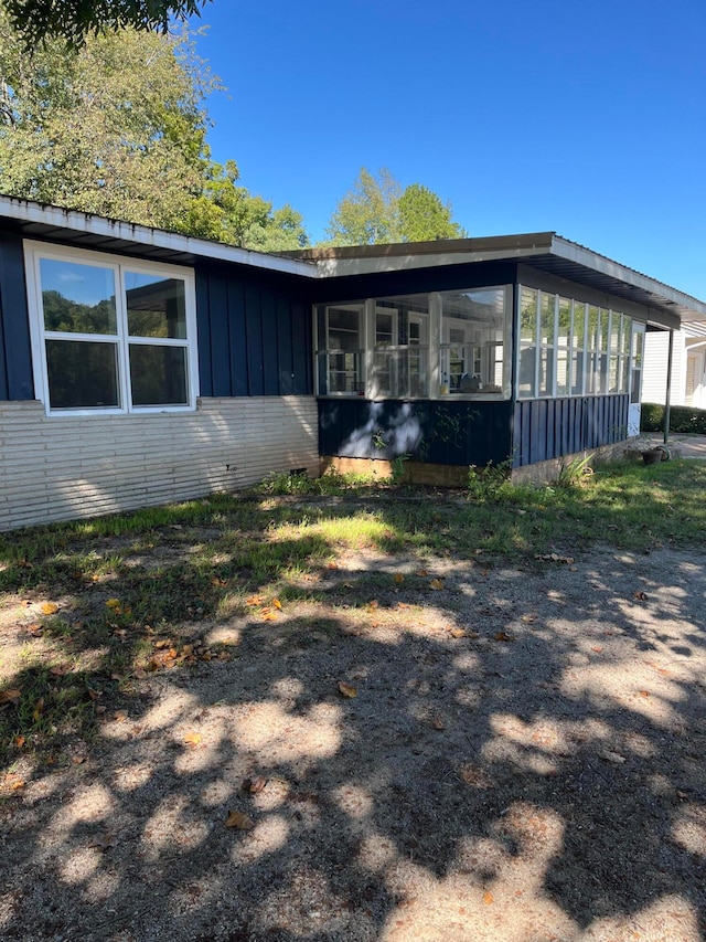 view of home's exterior with a sunroom