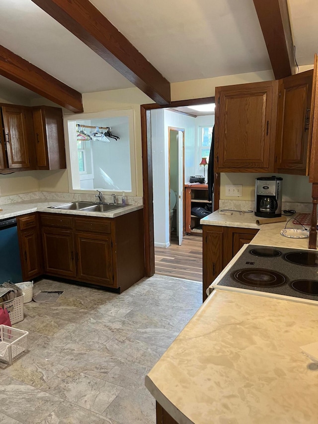 kitchen featuring dishwasher, beamed ceiling, sink, and range