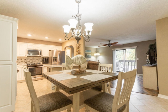 dining area with light tile patterned flooring and ceiling fan with notable chandelier