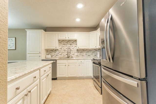 kitchen featuring white cabinets, appliances with stainless steel finishes, backsplash, and sink