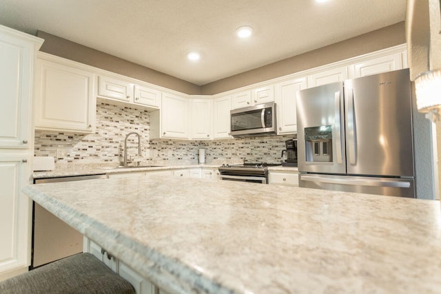 kitchen featuring appliances with stainless steel finishes, sink, and white cabinetry