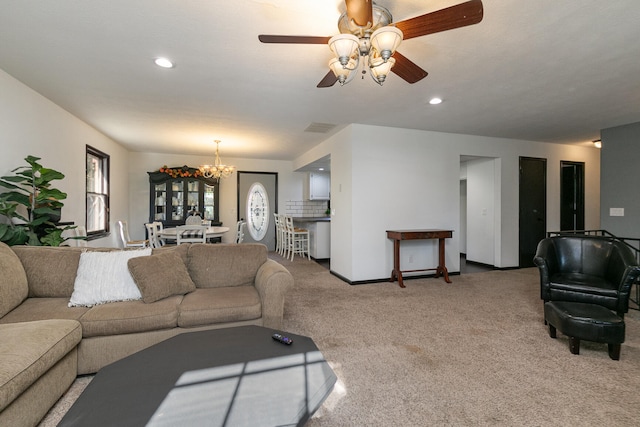 carpeted living room featuring ceiling fan with notable chandelier