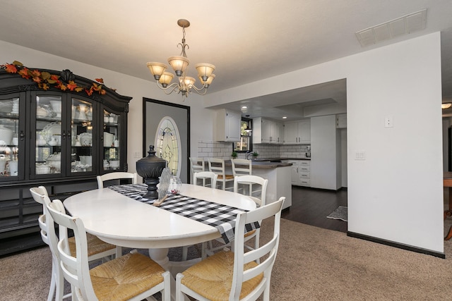 dining area featuring dark hardwood / wood-style floors and an inviting chandelier