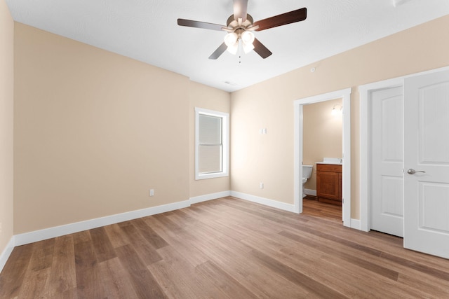 unfurnished bedroom with light hardwood / wood-style floors, connected bathroom, and ceiling fan