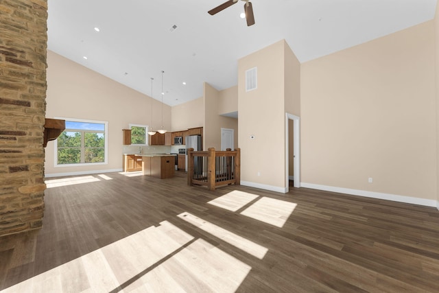 unfurnished living room with ceiling fan, dark hardwood / wood-style flooring, and high vaulted ceiling