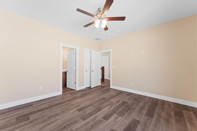 unfurnished bedroom featuring ceiling fan, connected bathroom, and dark hardwood / wood-style floors