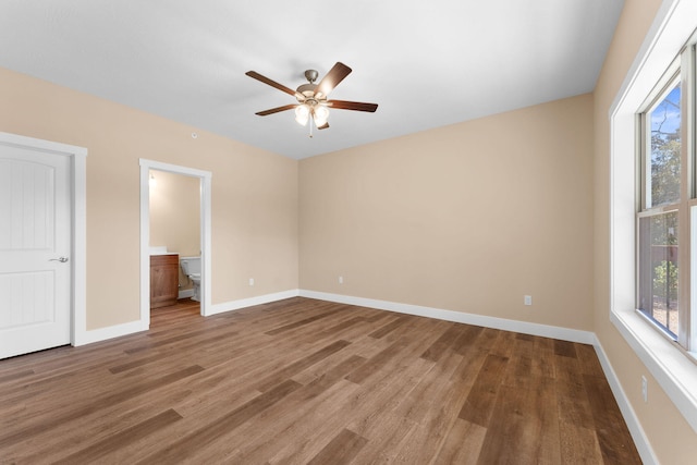 unfurnished bedroom with ceiling fan, connected bathroom, and hardwood / wood-style floors