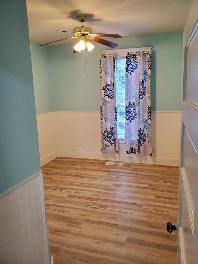 spare room with light wood-type flooring and ceiling fan