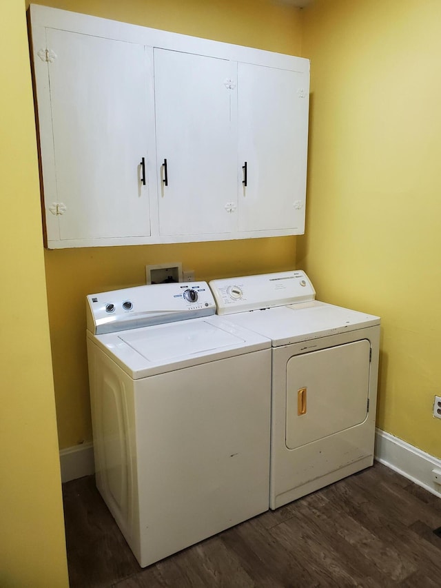 clothes washing area with cabinets, washer and dryer, and dark hardwood / wood-style flooring