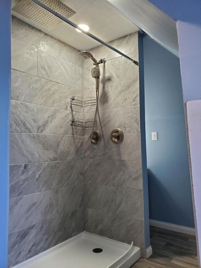 bathroom featuring a tile shower and hardwood / wood-style floors