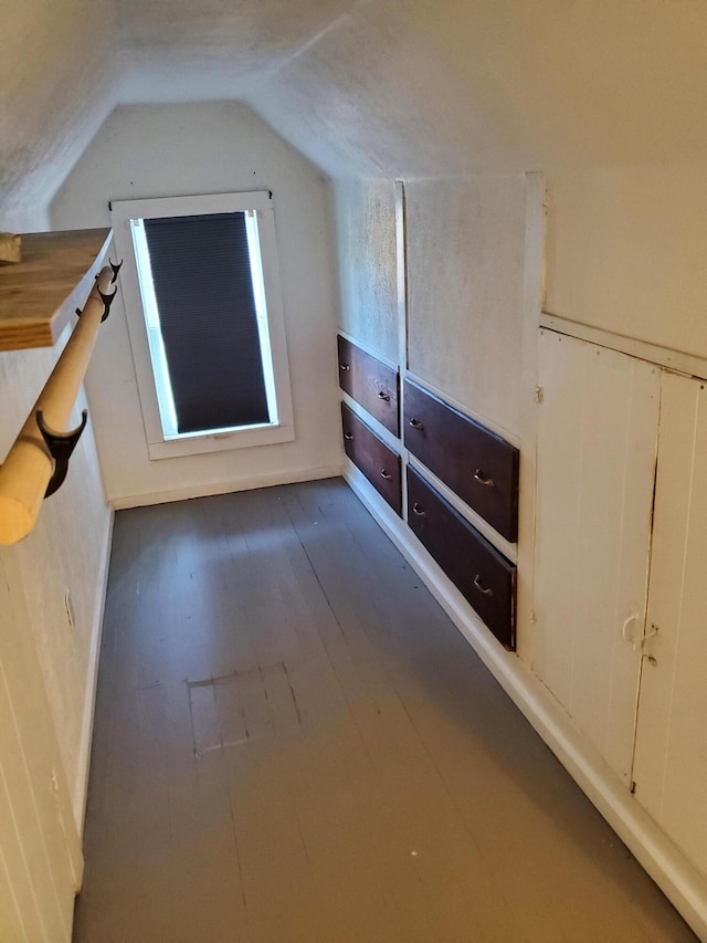 additional living space featuring lofted ceiling and dark hardwood / wood-style flooring