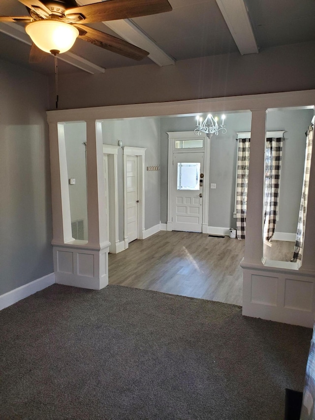 entryway with ceiling fan with notable chandelier, beamed ceiling, and hardwood / wood-style floors