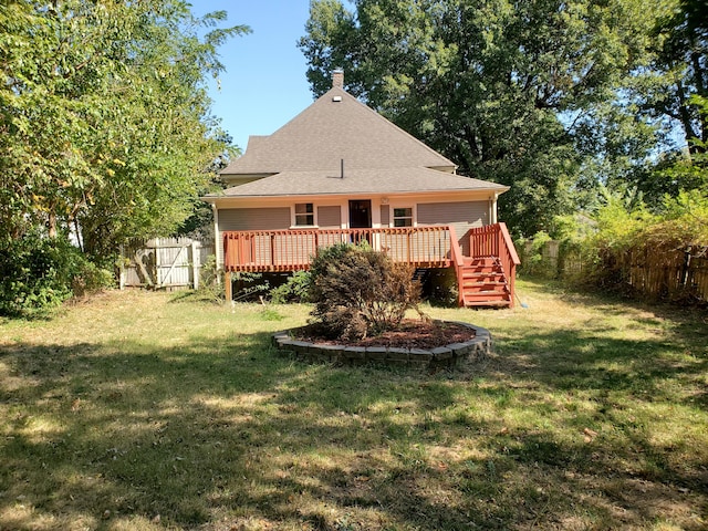 rear view of house with a wooden deck and a lawn