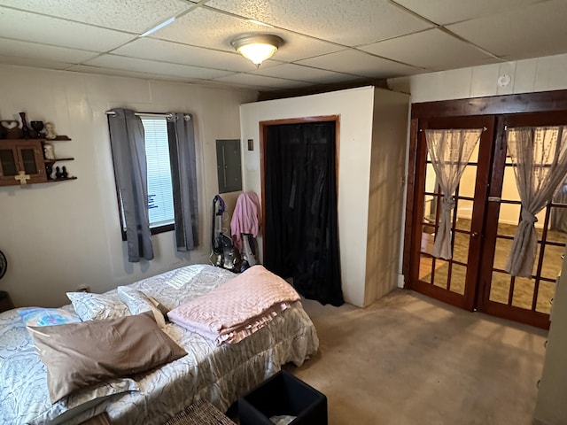 bedroom with electric panel, a paneled ceiling, and carpet flooring