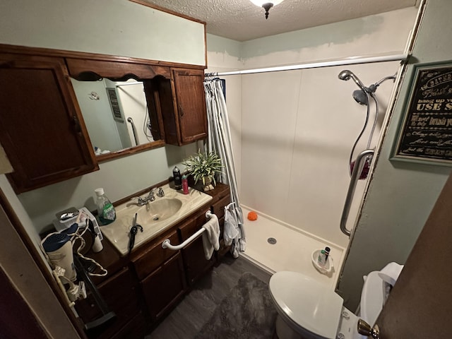 bathroom with a textured ceiling, vanity, toilet, and a shower with curtain