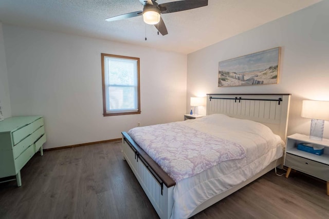 bedroom with ceiling fan, dark wood-type flooring, and a textured ceiling