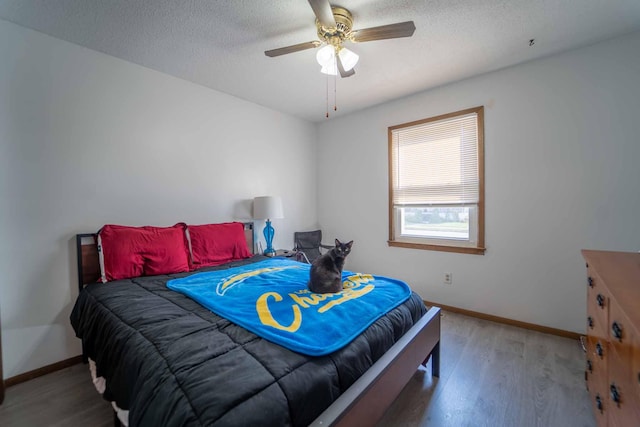 bedroom featuring ceiling fan, a textured ceiling, and wood-type flooring